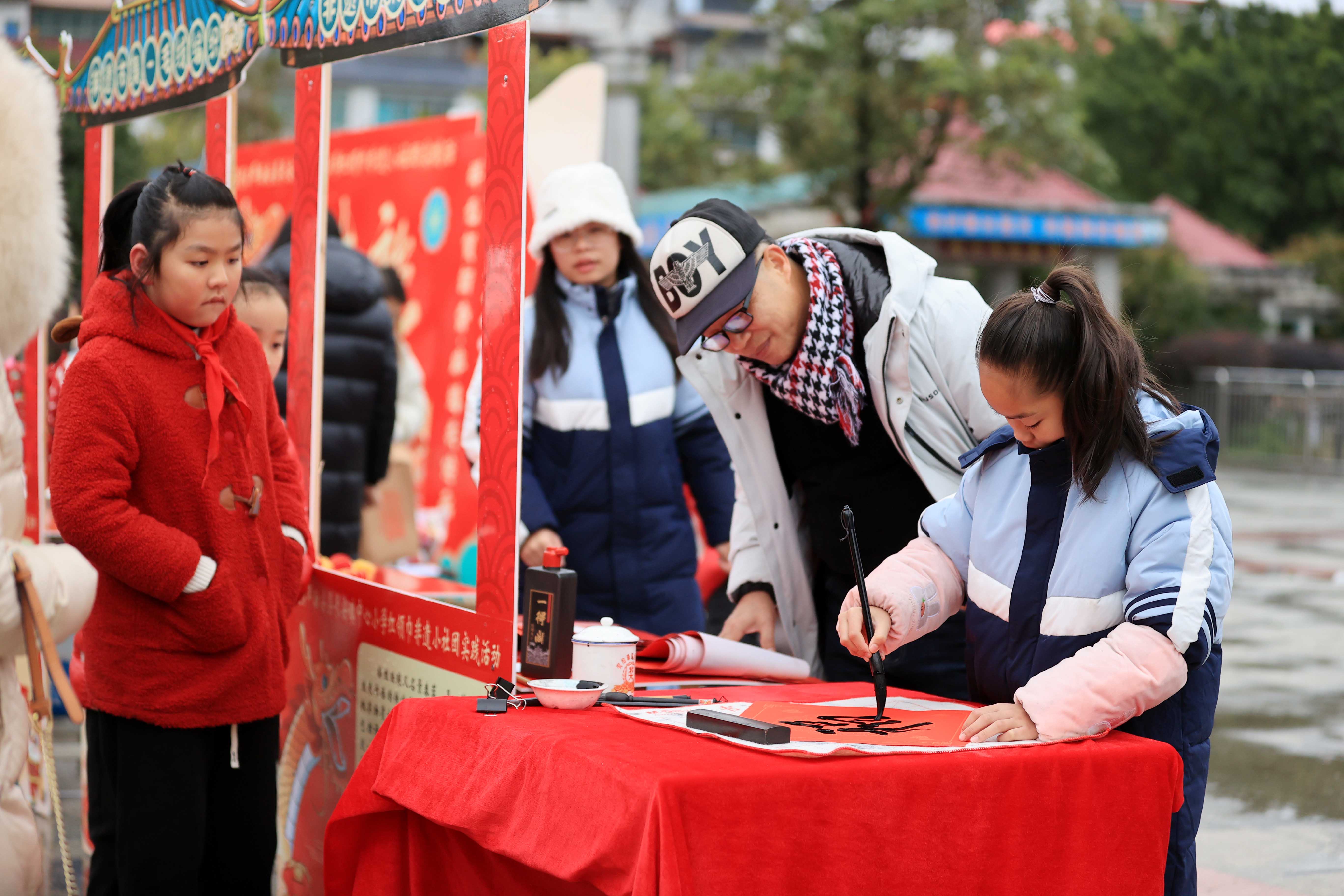 圖10：1月20日，在廣西柳州市融安縣長安廣場，一名小學生在書寫福字，準備贈送市民。（譚凱興 攝）.JPG