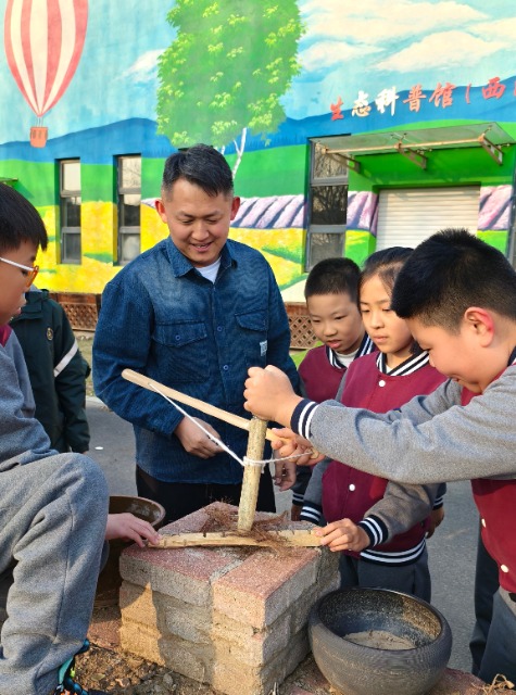 沈撫育才實(shí)驗(yàn)學(xué)校老師給學(xué)生們講解鉆木取火的科學(xué)原理.jpg