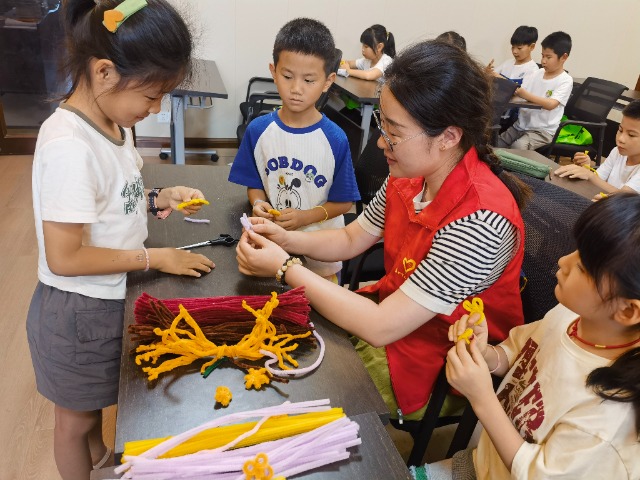 7月12日，在泰州市海陵區(qū)城東街道林湖社區(qū)，泰州市大浦小學“綠葉”暑期公益班的老師正在教孩子們一起做手工2（拍攝者：泰州市大浦中心小學  陳惠婷）.jpg